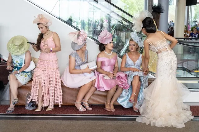 Race-goers rest between events at Ascot Racecourse on June 17, 2021 in Ascot, England. Gold Cup Day at the annual Royal Ascot race meeting has been affectionately known as Ladies Day since 1823. Traditionally women were given free or discounted tickets to the event and wore their finest fashions. Although today the discounts have been discontinued there is still a dress code for women attending the meet showing off extravagant clothing and outlandish millinery. (Photo by Leon Neal/Getty Images)