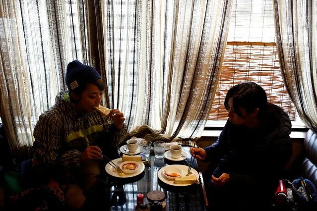Hunters Chiaki Kodama and Aoi Fukuno eat breakfast before their hunting trip in Oi, Fukui Prefecture, Japan, November 17, 2016. (Photo by Thomas Peter/Reuters)