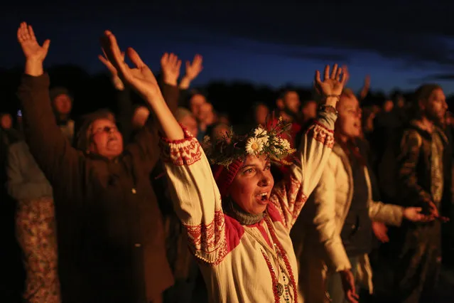 People wearing traditional Russian village-styled clothes, celebrate the summer solstice around a bonfire in Okunevo village, some 200 kilometers (124 miles) northeast from Siberian city of Omsk, Russia, Monday, June 21, 2021. The festivities of Ivan Kupala, or John the Baptist, are similar to Mardi Gras and reflect pre-Christian Slavic traditions and practices. (Photo by Evgeniy Sofiychuk/AP Photo)