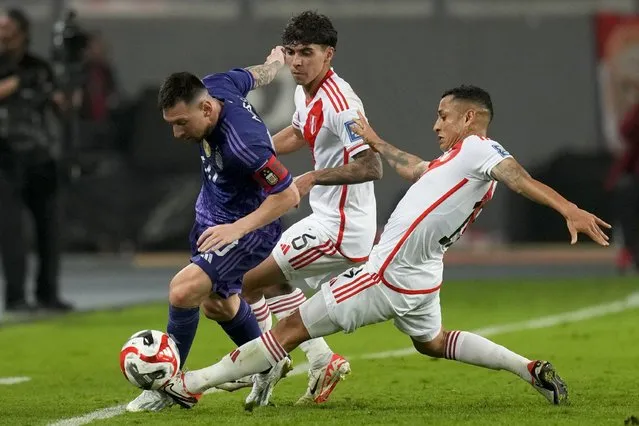 Argentina's Lionel Messi, left, fights for the ball with Peru's Yoshimar Yotun during a qualifying soccer match for the FIFA World Cup 2026 at the National stadium in Lima, Peru, Tuesday, October 17, 2023. (Photo by Martin Mejia/AP Photo)