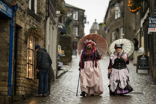 Steampunk enthusiasts attend the sixth annual Haworth Steampunk Weekend in Haworth, northern England on November 25, 2018. The three-day alternative lifestyle festival features: music, dancers, entertainers, burlesque performers, vintage vehicles, a fashion show and a masquerade ball. Steampunk is a subgenre of science fiction or science fantasy that incorporates technology and aesthetic designs inspired by 19th-century industrial steam-powered machinery. (Photo by Oli Scarff/AFP Photo)