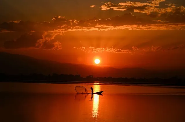 A fisherman casts his net in Dal Lake during sunset in Srinagar, India on September 28, 2023. (Photo by Tauseef Mustafa/AFP Photo)