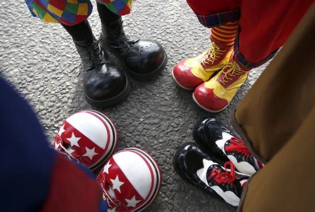Clowns stand together as they compare their shoes outside the All Saints Church before the Grimaldi clown service in Dalston, north London, February 7, 2016. (Photo by Peter Nicholls/Reuters)