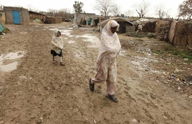 A woman and a girl walk on a muddy lane  on their way home in a slum on the outskirts of Islamabad February 16, 2015. (Photo by Faisal Mahmood/Reuters)