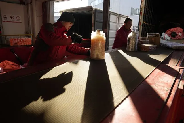 Workers sort out parcels at a distribution center for e-commerce platform JD.com in Beijing, Saturday, November 11, 2023. Shoppers in China have been tightening their purse strings, raising questions over how faltering consumer confidence may affect the annual Singles' Day online retail extravaganza. (Photo by Ng Han Guan/AP Photo)