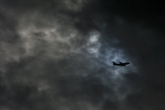 An aircraft is silhouetted against the grey sky as it flies over London, Britain January 26, 2016. (Photo by Stefan Wermuth/Reuters)