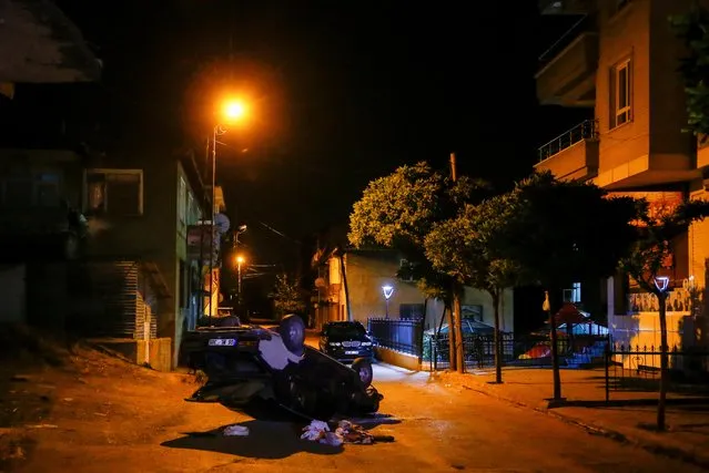 A toppled car is seen in the middle of a street during riots against refugees in Ankara, Turkey on August 12, 2021. (Photo by Cagla Gurdogan/Reuters)
