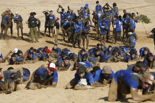 Israeli teenagers crawl as they participate in an annual combat fitness training competition, as part of their preparations ahead of their compulsory army service, near Kibbutz Yakum, central Israel February 19, 2016. (Photo by Baz Ratner/Reuters)