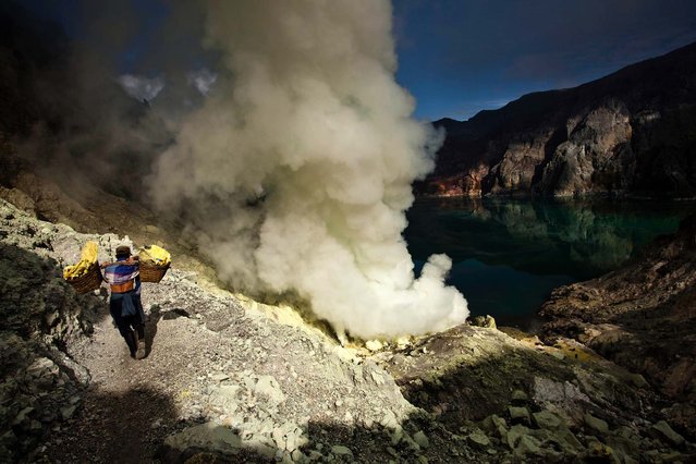 A miner carries sulfur during the ceremony. (Photo by Ulet Ifansasti/Getty Images)