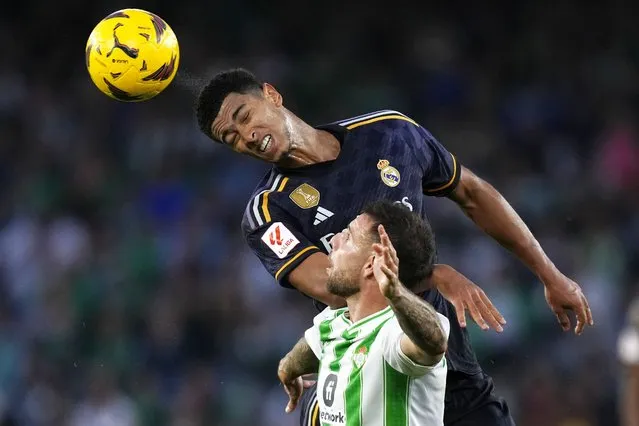 Real Madrid's Jude Bellingham, top, jumps for a header above Betis' Aitor Ruibal during a Spanish La Liga soccer match between Betis and Real Madrid at the Benito Villamarin stadium in Seville, Spain, Saturday, December 9, 2023. (Photo by Jose Breton/AP Photo)