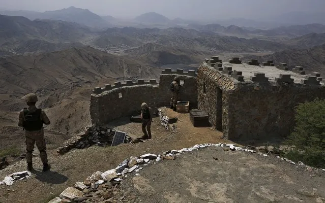 Pakistan Army troops observe the area from hilltop post on the Pakistan Afghanistan, in Khyber district, Pakistan, Tuesday, August 3, 2021. Pakistan's military said it completed 90 percent of the fencing along the border with Afghanistan, vowing the remaining one of the most difficult tasks of improving the border management will be completed this summer to prevent any cross-border militant attack from both sides. (Photo by Anjum Naveed/AP Photo)