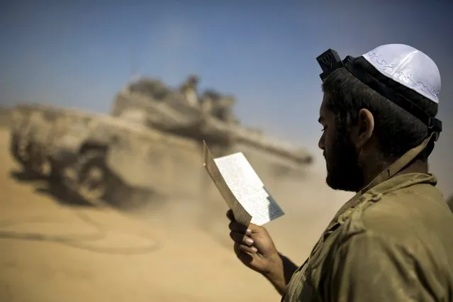 An Israeli soldier prays at a staging area outside the northern Gaza Strip, in this July 27, 2014 file photo. Israel's long-running struggle to balance modern standards with Jewish tradition has come to a head in the military, where new orders curtailing beards among soldiers have met protests from some rabbis. (Photo by Amir Cohen/Reuters)