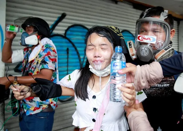 A demonstrator gets assistance during a protest for the government's handling of the coronavirus disease (COVID-19) pandemic, in Bangkok, Thailand on August 13, 2021. (Photo by Soe Zeya Tun/Reuters)