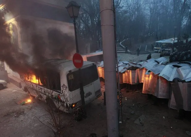 A police van burns after being attacked by Pro-European integration protesters during a rally near government administration buildings in Kiev January 19, 2014. Protesters on the sidelines of an anti-government rally in Ukraine clashed on Sunday with riot police, attacking them with sticks and trying to overturn a bus commandeered by police to block the main road leading to parliament. (Photo by Gleb Garanich/Reuters)