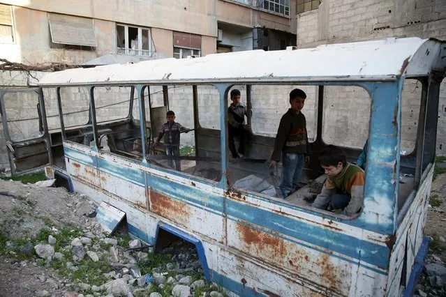 Children play in a damaged school bus in the rebel held besieged town of Jesreen, in the eastern Damascus suburb of Ghouta, Syria March 7, 2016. (Photo by Bassam Khabieh/Reuters)
