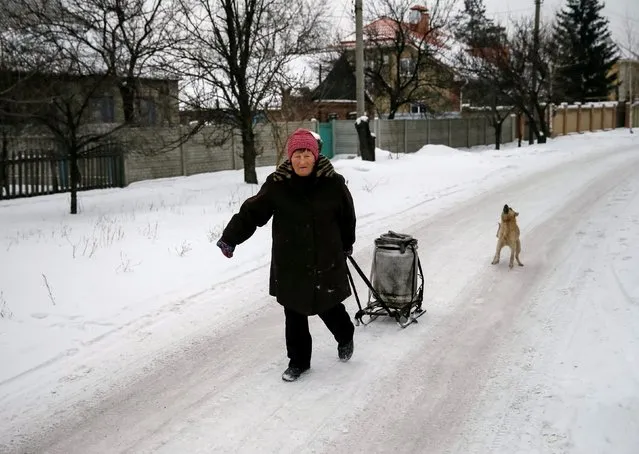 A local resident carries a can with water in the government-held industrial town of Avdiyivka, Ukraine, February 2, 2017. (Photo by Gleb Garanich/Reuters)