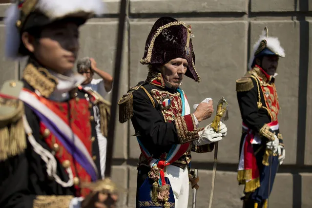 Mexican businessman Jorge Monsalvo, center, portrays Napoleon III as he walks with other men dressed as French officers ahead of a reenactment of the battle of Puebla between Zacapoaxtlas Indians and the French army, during Cinco de Mayo celebrations in the Penon de los Banos neighborhood of Mexico City, Tuesday, May 5, 2015. (Photo by Rebecca Blackwell/AP Photo)