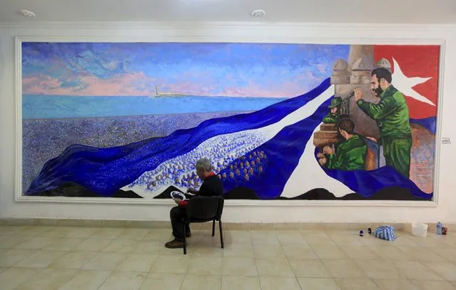 Mexican painter Arturo Navarrete, 62, paints a mural with a Cuban flag and the former Cuban president Fidel Castro in Havana March 17, 2016. (Photo by Enrique De La Osa/Reuters)