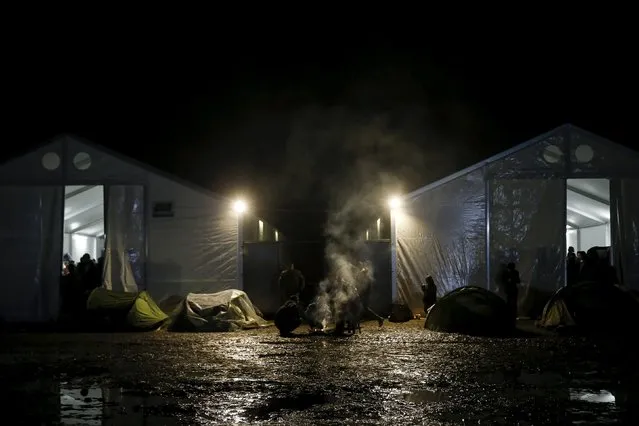 A bonfire smokes next to tents at a makeshift camp at the Greek-Macedonian border, near the village of Idomeni, Greece March 16, 2016. (Photo by Alkis Konstantinidis/Reuters)