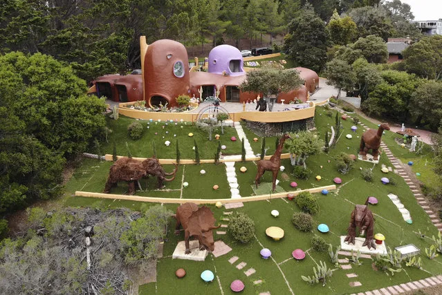 This Monday, April 1, 2019 photo, shows an aerial view of the Flintstone House in Hillsborough, Calif. The San Francisco Bay Area suburb of Hillsborough is suing the owner of the house, saying that she installed dangerous steps, dinosaurs and other Flintstone-era figurines without necessary permits. The owner and her attorney say they will fight for the rights of property owners and Fred and Barney fans everywhere. (Photo by Terry Chea/AP Photo)