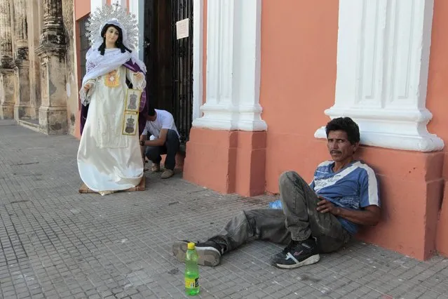 A man sits next to a statue of the Virgin Mary before the start of “Jesus del gran poder” procession in the colonial city of Granada, Nicaragua March 22, 2016. (Photo by Oswaldo Rivas/Reuters)