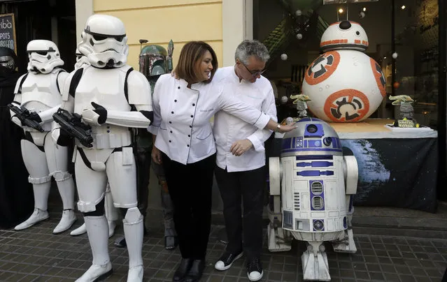 Pastry chef Christian Escriba (C-R) poses scorted by Imperial Army troopers during the presentation of his Easter cake with the shape of the BB-8 droid from the Star Wars (R, rear) on Good Friday in Barcelona, northeastern Spain, March 25, 2016. (Photo by Alberto Estevez/EPA)