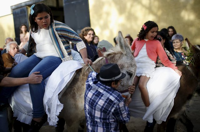Two girls sit on donkeys before joining in the “Virgem da Atalaia” procession during Holy Week at Alcochete, near Lisbon, Portugal March 27, 2016. (Photo by Rafael Marchante/Reuters)