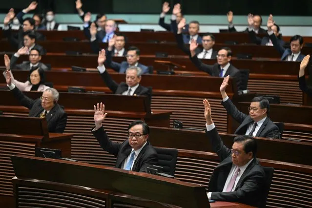 Lawmakers vote for Article 23 in the chamber of the Legislative Council after the conclusion of the readings of the Article 23 National Security Law, in Hong Kong on March 19, 2024. Hong Kong's legislature unanimously passed a new national security law on March 19, introducing penalties such as life imprisonment for crimes related to treason and insurrection, and up to 20 years' jail for the theft of state secrets. (Photo by Peter Parks/AFP Photo)