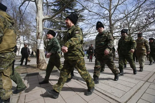 Cossacks march at the local parliament building in Crimea's capital Simferopol, Ukraine, Thursday, March 6, 2014. About 50 people rallied outside the local parliament Thursday morning waving Russian and Crimean flags. (Photo by Sergei Grits/AP Photo)