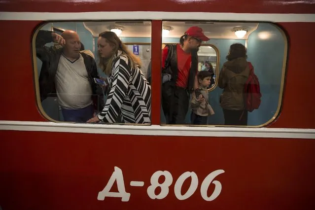 People examine the interior of a Soviet-era vintage subway car parked in the Partizanskaya subway station in Moscow, Russia, Friday, May 15, 2015. (Photo by Pavel Golovkin/AP Photo)