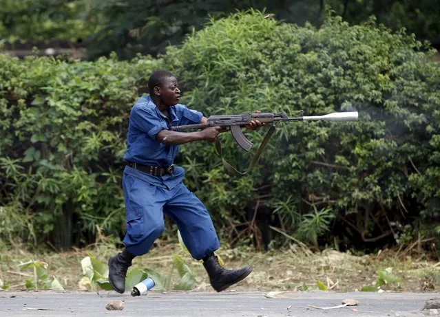 A policeman fires a rifle during a protest against Burundi President Pierre Nkurunziza and his bid for a third term in Bujumbura, Burundi, May 21, 2015. (Photo by Goran Tomasevic/Reuters)
