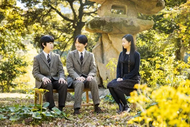 This handout picture taken on November 12, 2021 and provided by the Imperial Household Agency of Japan on November 30, 2021 shows Japan’s Crown Prince Akishino (C) sitting with his son Prince Hisahito (L) and his daughter Kako (R) in the garden of their Akasaka imperial property residence in Tokyo, ahead of his 56th birthday on November 30. (Photo by Kazuhiro Nogi and Handout/Imperial Household Agency via JIJI Press/AFP Photo)