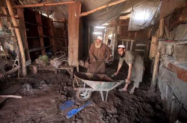 Shopkeepers remove mud from their shop after floodwaters receded in Sarband area on the outskirts of Peshawar, Pakistan April 5, 2016. (Photo by Fayaz Aziz/Reuters)
