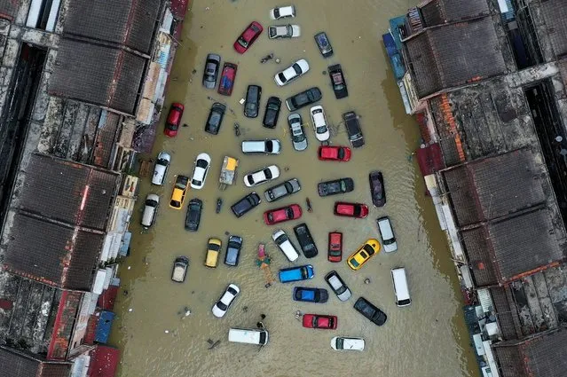 Aerial view shows vehicles and buildings inundated by floods in Shah Alam's Taman Sri Muda, one of the worst hit neighbourhoods in Selangor state, Malaysia, December 21, 2021. Picture taken with a drone. (Photo by Ebrahim Harris/Reuters)