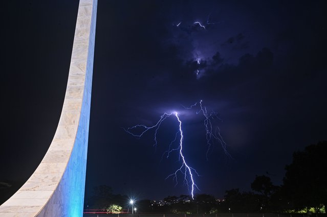 A lightning strike lights up the sky during a rainstorm in the background of the Supreme Federal Court (STF) in Brasilia, Brazil, 28 September 2023. (Photo by Andre Borges/EPA)