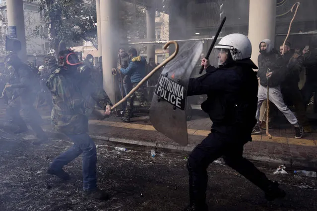 Greek farmers protesting higher taxes clash with riot police outside the Agriculture ministry in Athens, on March 8, 2017. Two people were detained after the windows of two police vans were smashed as approximately 1,000 farmers, mainly from the island of Crete, took part in the protest. (Photo by Louisa Gouliamaki/AFP Photo)