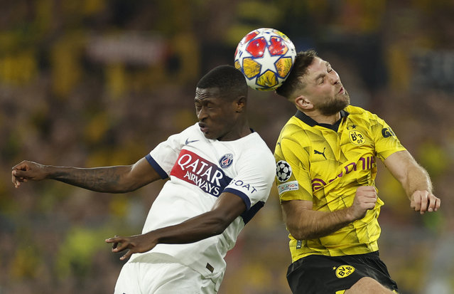 Paris Saint-Germain's Portuguese defender #02 Nuno Mendes (L) and Dortmund's German forward #14 Niclas Fuellkrug vie for the ball during the UEFA Champions League semi-final first leg football match between Borussia Dortmund and Paris Saint-Germain (PSG) on May 1, 2024 in Dortmund. (Photo by Odd Andersen/AFP Photo)
