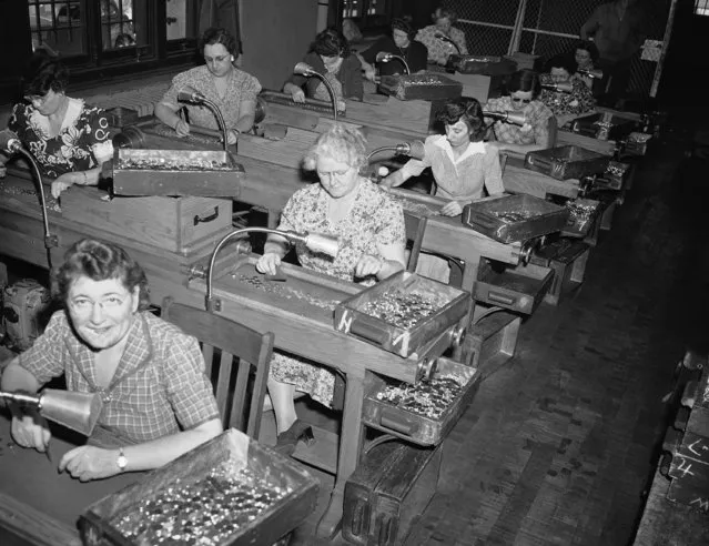 The women sort coins before they go to the stamping machine in Philadelphia, Pa., circa 1942. (Photo by AP Photo)