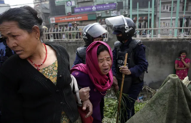 A woman cries as her temporary home was torn down by police in a quake victims' shelter in downtown Kathmandu, Nepal, Tuesday, March 14, 2017. Police tore down hundreds of temporary homes in the Nepalese capital where people who lost their homes in the 2015 earthquake have been living for two years. (Photo by Niranjan Shrestha/AP Photo)