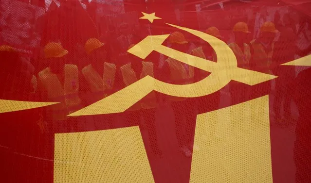 People walk behind a red banner with hammer and sickle symbols during a May Day rally in Istanbul, Turkey, May 1, 2016. (Photo by Murad Sezer/Reuters)