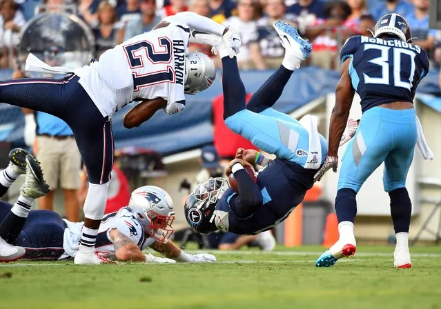 Tennessee Titans quarterback Marcus Mariota (8) is flipped by New England Patriots strong safety Duron Harmon (21) as he scores on a two point conversion during the first half at Nissan Stadium in Nashville, Tennessee, August 17, 2019. (Photo by Christopher Hanewinckel/USA TODAY Sports)