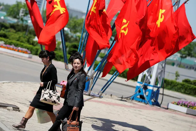 Workers' Party of Korea (WPK) flags decorate an intersection as women cross the street in central Pyongyang, North Korea, May 7, 2016. (Photo by Damir Sagolj/Reuters)