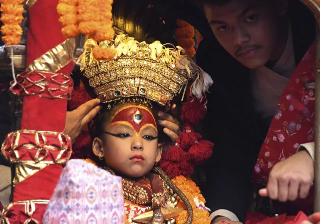 A Nepali child revered as a living goddess or Kumari, is carried in a chariot during a procession on the main day of the Indra Jatra festival at Basantapur Durbar Square in Kathmandu on September 13, 2019. Nepal's week-long festival celebrates “Indra”, the king of gods and the god of rains. Every September, the living goddess is carried on a palanquin in a religious procession through parts of the capital in a festival celebrated by Nepalese Hindus and Buddhists. (Photo by Prakash Mathema/AFP Photo)