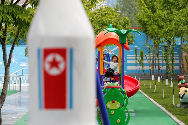 A girl yawns behind a rocket shaped merry-go-around with North Korean flag at the kindergarten of the Kim Jong Suk Pyongyang textile mill during a government organised visit for foreign reporters in Pyongyang, North Korea May 9, 2016. (Photo by Damir Sagolj/Reuters)