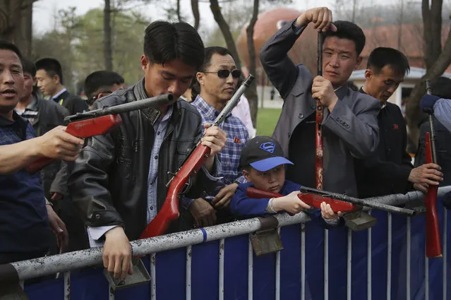 In this Sunday, April 16, 2017, photo, North Korean men and a young boy play shooting games at the Central Zoo during a holiday weekend as part of celebrations for the 105th birth anniversary of their late leader Kim Il Sung in Pyongyang, North Korea. Tensions have spiked in recent weeks over North Korea's advancing nuclear technology and missile arsenal. But in Pyongyang, where war would mean untold horrors, where neighborhoods could be reduced to rubble and tens of thousands of civilians could be killed, few people seem to care much at all. (Photo by Wong Maye-E/AP Photo)