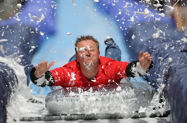 A participant on a lilo slides down a giant water slide that has been installed down Park Street on May 4, 2014 in Bristol, England. (Photo by Matt Cardy/Getty Images)