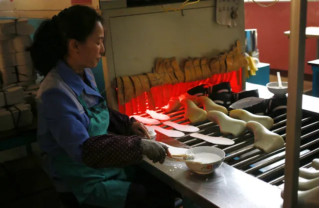 In this Friday, February 1, 2019, photo, a worker tend to her station at Ryuwon Shoe Factory that specializes in sports footwear, in Pyongyang, North Korea. North Korean pop culture, long dismissed by critics as a kitschy throwback to the dark days of Stalinism, is getting a major upgrade under leader Kim Jong Un. The changes are being seen in everything from television dramas and animation programs to the variety and packaging of consumer goods, which have improved significantly under Kim. (Photo by Dita Alangkara/AP Photo)