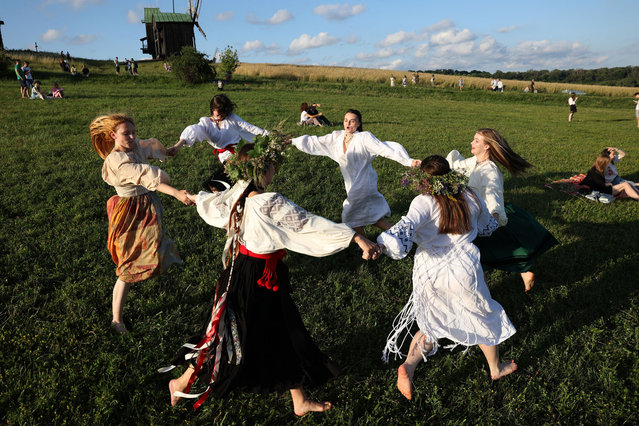 Participants dance during the celebration of the Pagan holiday of Ivan Kupala, a traditional holiday that has been observed in Ukraine since pre-Christian times, in Kyiv, on June 23, 2024, amid the Russian invasion in Ukraine. (Photo by Anatolii Stepanov/AFP Phoot)