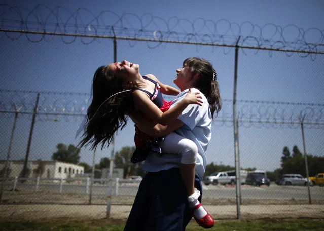 Cori Walters, 32, (R) hugs her daughter Hannah Walters, 6, at California Institute for Women state prison in Chino, California May 5, 2012. (Photo by Lucy Nicholson/Reuters)