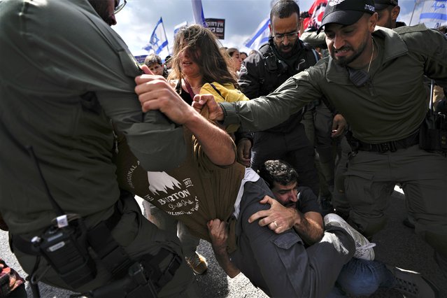 Israelis scuffles with police during a protest against Prime Minister Benjamin Netanyahu's judicial overhaul plan outside the parliament in Jerusalem, Monday, March 27, 2023. (Photo by Ariel Schalit/AP Photo)